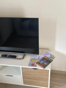 una TV a schermo piatto seduta sopra un centro di intrattenimento bianco di Da Pippo a Moneglia
