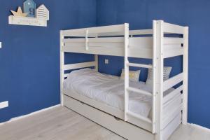 ein weißes Etagenbett in einem blauen Zimmer in der Unterkunft Calme, detente et decouvertes en famille in Plobannalec-Lesconil