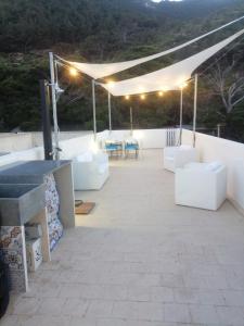 a patio with white couches and tables and lights at HIERA CASAVACANZE in Marettimo