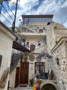 Edificio de piedra con escaleras y balcón en Bayar Cave Suites, en Ürgüp
