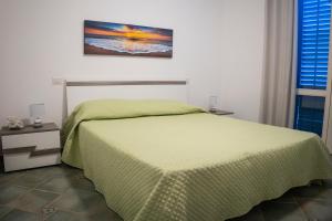 a bedroom with a bed with a green comforter at HIERA CASAVACANZE in Marettimo