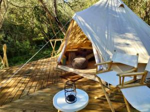 Jurte mit einem Tisch und Stühlen auf einer Holzterrasse in der Unterkunft Gaia Double or Twin Bell Tent in Swellendam