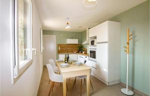 cocina con mesa de madera y armarios blancos en Beautiful Home In Montboucher Sur Jabron With House A Panoramic View en Montboucher-sur-Jabron