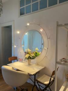 un tavolo con specchio rotondo e un tavolo con fiori di Appartement au centre de Lons a Lons-le-Saunier