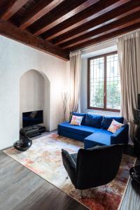 ein Wohnzimmer mit einem blauen Sofa und einem Kamin in der Unterkunft Rosa Luxury Apartment in Verona