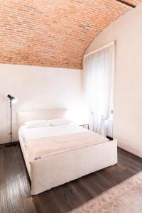 ein Schlafzimmer mit einem großen weißen Bett und einer Ziegeldecke in der Unterkunft Rosa Luxury Apartment in Verona