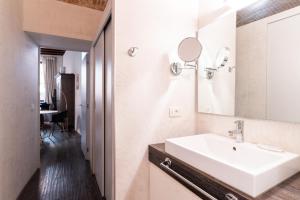 a bathroom with a white sink and a mirror at Rosa Luxury Apartment in Verona