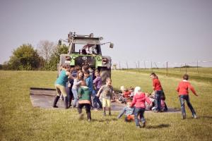 un groupe d’enfants debout devant un tracteur dans l'établissement Seeschwalbe, à Bliesdorf