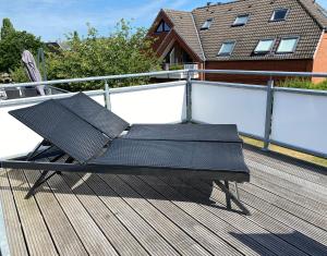 a black bench sitting on the deck of a house at Luv-Lee in Grömitz