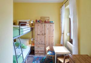 RettinにあるStrandperleの二段ベッドとテーブルが備わる小さな客室です。