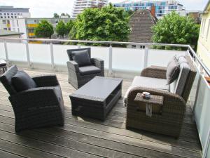 a deck with chairs and tables on a balcony at Penthouse Parkblick in Grömitz