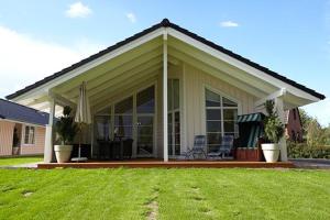 a house with a patio with chairs on a lawn at Wellnesshaus Austernperle in Bliesdorf