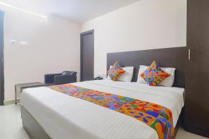 a bedroom with a large bed with a colorful blanket at FabHotel Akshara Innotel in Visakhapatnam
