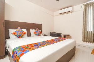 een slaapkamer met een groot bed en een kleurrijke deken bij FabHotel Akshara Innotel in Visakhapatnam