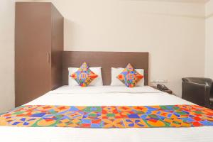 a bedroom with a bed with a colorful bedspread at FabHotel Akshara Innotel in Visakhapatnam