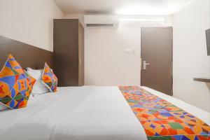 a bedroom with a large bed with colorful pillows at FabHotel Akshara Innotel in Visakhapatnam