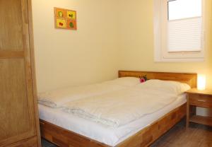 Bett in einem Zimmer mit Fenster in der Unterkunft Dana in Grömitz