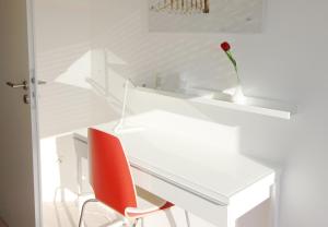 ノイシュタット・イン・ホルシュタインにあるPenthouse Meeresrauschenの白いデスク(赤い椅子、花瓶付)