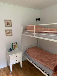 a bedroom with two bunk beds and a night stand at Solhøj - a nice quite place just outside Billund in Billund