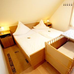 ein kleines Schlafzimmer mit einem Bett und einem Kinderbett in der Unterkunft Seestern in Bliesdorf