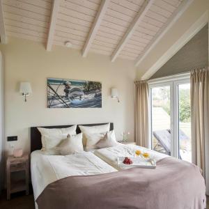 ein Schlafzimmer mit einem großen Bett und einem Tablett mit Obst darauf in der Unterkunft Luxuswellnesshaus Weitblick in Bliesdorf