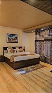 a bedroom with a large bed and curtains at Hotel Saima in Srinagar