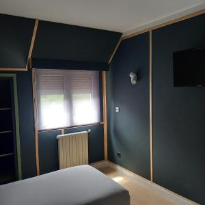 a bedroom with a bed and a window with a radiator at HMC K-ena in Andorra la Vella