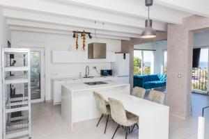 a white kitchen with a table and chairs at Villa Siesta in Denia