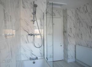 a bathroom with a shower and a bath tub at Valley Road, Fabulous 4 bedroom house in Harrogate