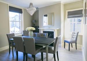 a dining room with a table and chairs and a chandelier at Valley Road, Fabulous 4 bedroom house in Harrogate