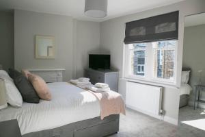 a bedroom with a bed and a television and a window at Valley Road, Fabulous 4 bedroom house in Harrogate