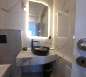 a bathroom with a sink and a mirror at Paros Blue Dolphin FULLY RENOVATED by RIVEA GROUP in Chrissi Akti