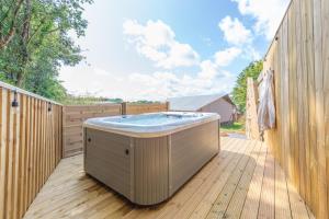 bañera de hidromasaje en una terraza de madera en Luxury Glamping at Stags Head, en Abbotskerswell