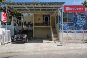 a truck parked in front of a building with a garage at RedDoorz Syariah near Universitas Mercu Buana Kampus 2 Yogyakarta in Yogyakarta