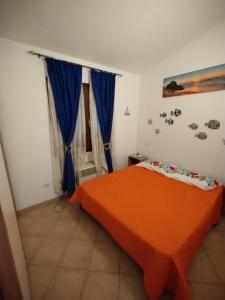 ムルタ・マリアにあるBaia Turchese A36のベッドルーム(オレンジ色のベッド、青いカーテン付)