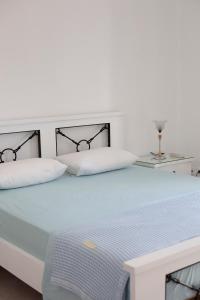a white bed with a black headboard and white pillows at Hara's Studio in Perdika