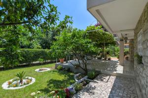 un patio con un jardín con flores y árboles en Apartments Elena, en Budva