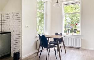 d'une salle à manger avec une table, des chaises et une fenêtre. dans l'établissement Elperhof Appartement 1, à Schoonloo