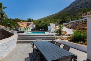 une terrasse avec une table et une piscine dans l'établissement Villa Siesta, à Dénia