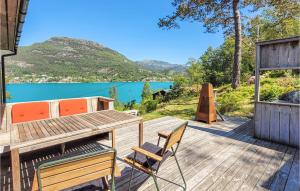 a deck with a table and chairs and a view of a lake at Amazing Home In Jrpeland With Kitchen in Jørpeland