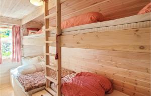 two bunk beds in a room with wooden walls at Beautiful Home In Jrpeland With Wifi And 2 Bedrooms in Jørpeland