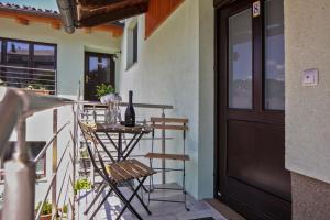 a balcony with a door and a table with a bottle of wine at Guesthouse Turšič in Vrhnika