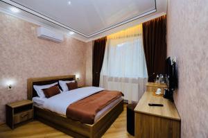 a bedroom with a large bed and a window at Hotel Evergreen in Borjomi