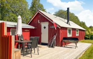 Amazing Home In Skage I Namdalen With Kitchen في Overhalla : حظيرة حمراء مع طاولة وشواية