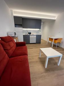 a living room with a red couch and a white table at Anzaran in Irún