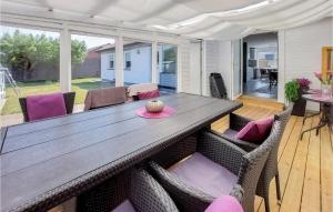 een houten tafel en stoelen in de woonkamer bij Cozy Home In Helsingborg With Private Swimming Pool, Can Be Inside Or Outside in Helsingborg