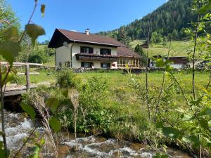 a house on a hill next to a river at Haus Christina in Döllach