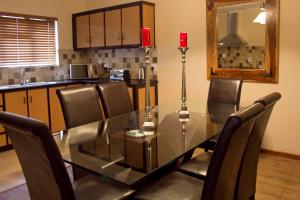 a dining room with a glass table and chairs at Bakgat Blyplek in Beaufort West