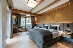 um quarto com uma cama grande e paredes de madeira em NOVA Moments Boutique Hotel em Pertisau