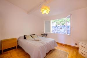 1 dormitorio con cama blanca y ventana en Villa Magalinette - Maison pour 6 avec piscine, en Mougins